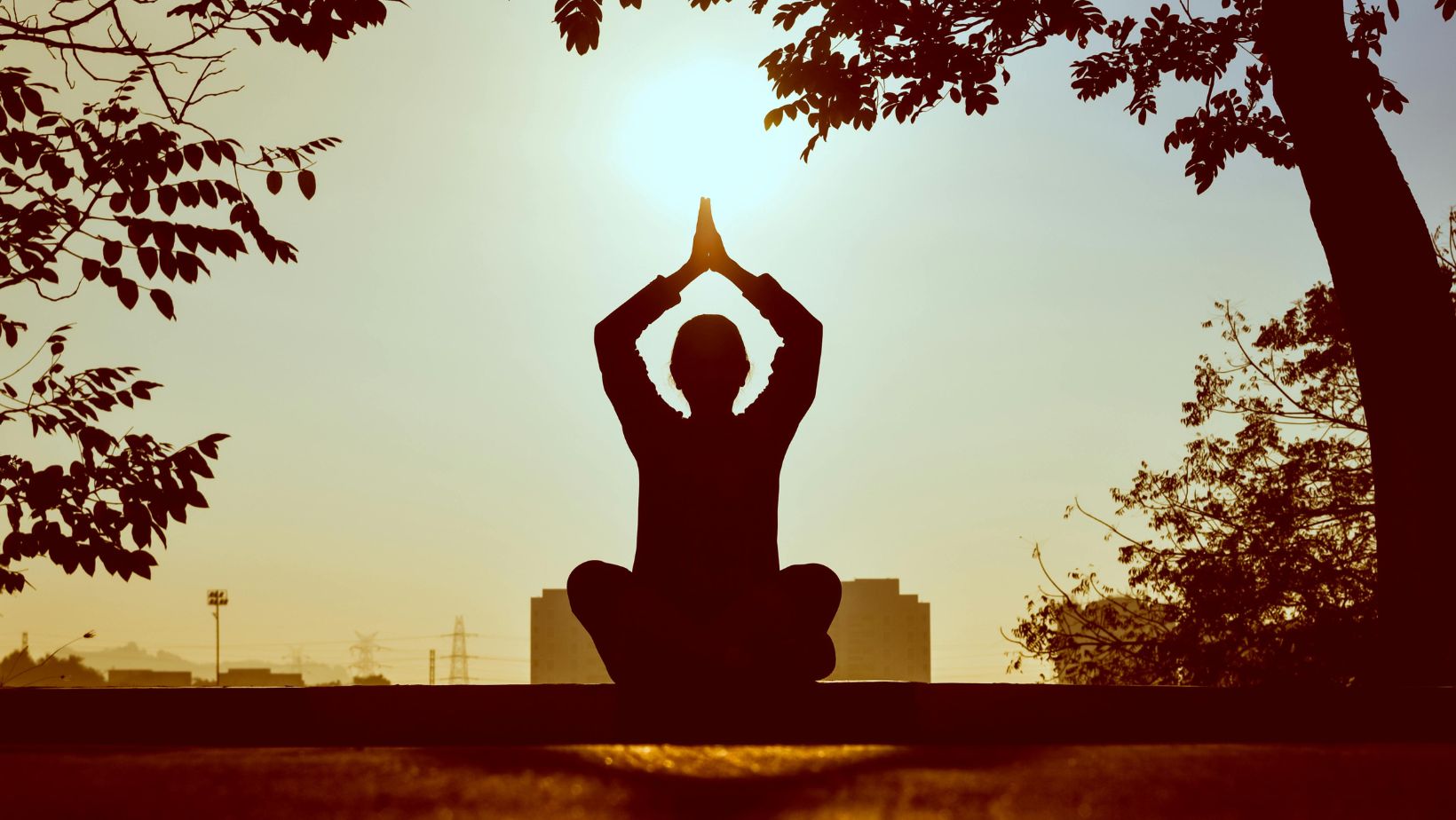 Silhouette of a person doing yoga during sunset